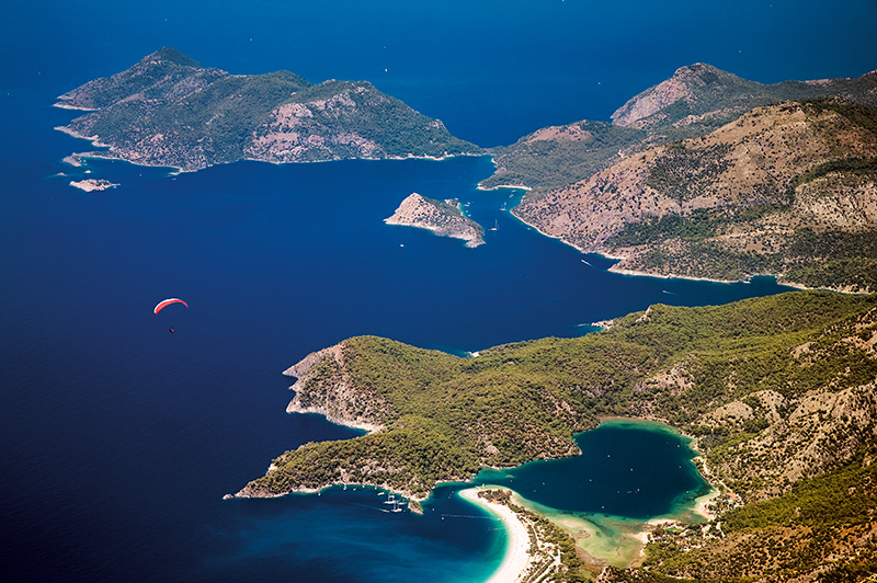 Ölüdeniz, Karacaören Koyu ve Gemiler Adası, Babadağ’dan yamaç paraşütüyle uçanların manzarasını süslüyor. Lykialılar antikçağda Ölüdeniz’e ışık ve güneş diyarı diyorlardı. Fotoğraf: Tolga Sezgin