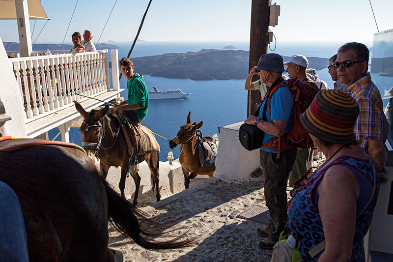 Santorini’de günbatımının en iyi gözlemlendiği yer olan Oia’ya teleferikle ve “adanın geleneksel ulaşım aracı” eşeklerle çıkılıyor.